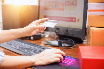 Hands holding credit card and using computer. Online shopping
