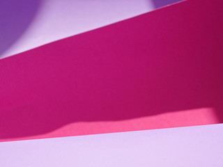 Abstract background made of red and purple sheets of thick paper twisted together. Shallow depth of field.