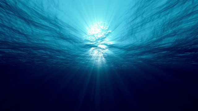 Slow motion of clean water looping light underwater video with beams of sunlight. 4K seamless loop