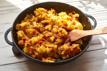 Baked potatoes with minced meat, onions and carrots baked in a pan.