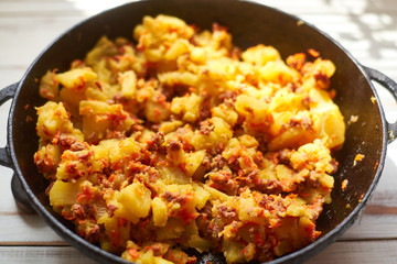 Baked potatoes with minced meat, onions and carrots baked in a pan.