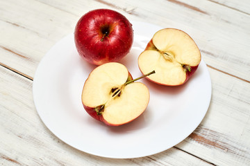Naklejka na ściany i meble Ripe red apples on a plate on a wooden background.