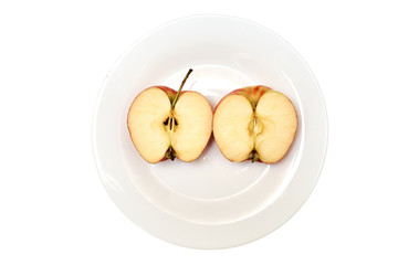 Naklejka na ściany i meble Half an apple on a plate. Isolated on a white background.
