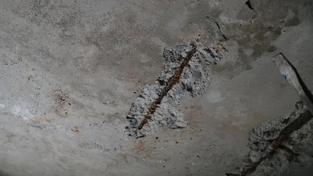  Exposed reinforcement on the crumbling concrete, defect of cement structure 