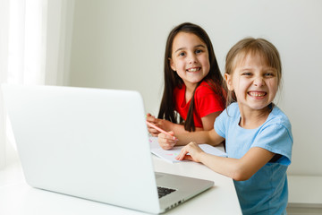 Pretty stylish schoolgirls studying math during her online lesson at home, social distance during...