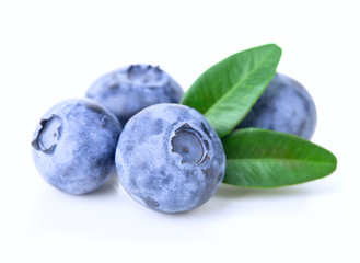 Ripe juicy blueberries with leaves isolated on a white background.