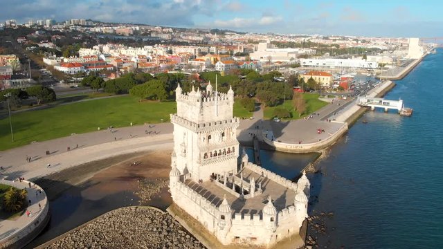 4k Aerial drone view of Belem Tower in Lisbon Portugal with cityscape in background.