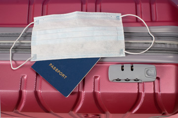 Travel suitcase, passport and medical mask. Stop travel during the epidemic coronavirus. Quarantine concept.