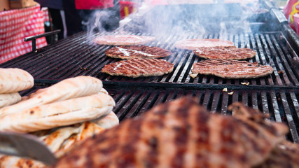 Smoky hamburger meat grilling for meal.