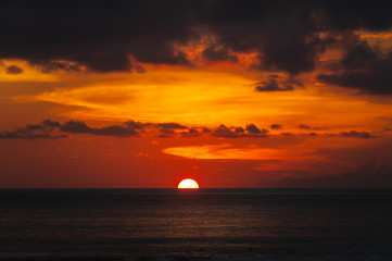 Naklejka na ściany i meble Stunning dramatic sunset over the ocean.