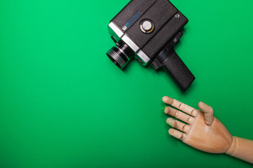 A wooden hand reaches out to the camera on a background of a green background. Video production. Hromakey. Close-up