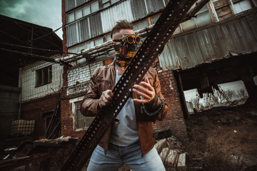 a young man in a factory during the Apocalypse in a castle and with a saw