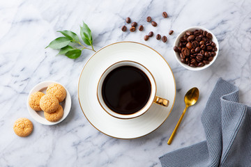 Cup of black coffee with amaretti cookies on marble table. Top view.