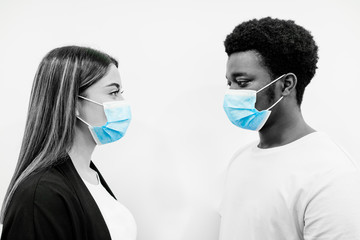 Portrait of black afro man and Caucasian girl face to face with a blue face mask