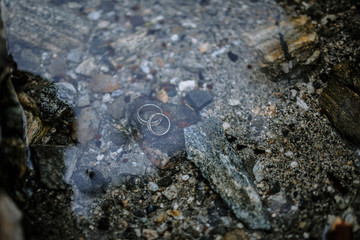 Wedding rings lying under the water at the bottom of the lake