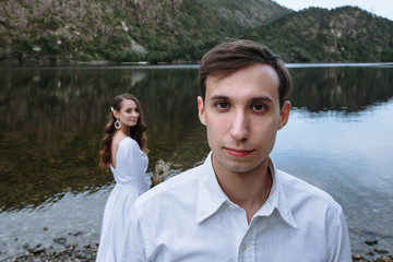 Wedding couple standing on the shore of the lake