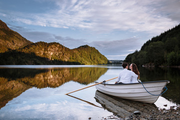 Wedding couple sitting hugging in a boat on the lake