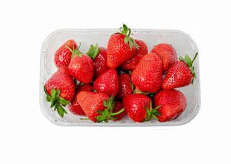 Heap of vivid red ripe strawberries in plasctic transparent container isolated on clear white background