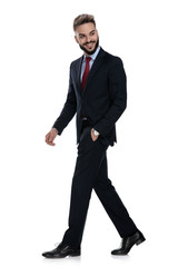 happy young businessman looking to side and walking