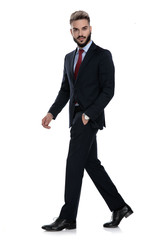 sexy young businessman holding hands in pockets and walking