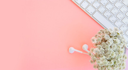 pink office desk with smartphone with blank screen mockup, laptop computer, cup of coffee and supplies. Top view with copy space, flat lay.