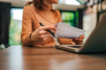 Fototapeta premium Businesswoman holding mail at office desk, close-up.