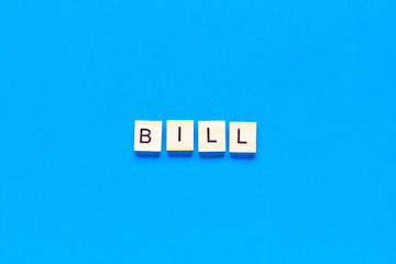 bill in wooden letters on a blue background, flat layout, top view, banner