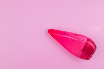 Body lotion in red bottle on pink background