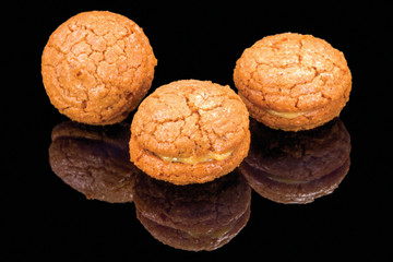 delicious cookies with walnuts and cream with reflection, isolated on black background.