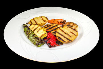 Gourmet mixed BBQ vegetables on a white plate, isolated on black background