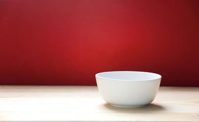 White bowl on wooden table red empty space background.Food backdrop.