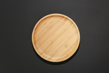 Wooden dish on black top view,food plate empty space.