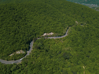 Mountain winding zig zag road. Top aerial view: cars driving on road from above.