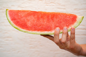 Closeup fresh organic slice of watermelon in hand 