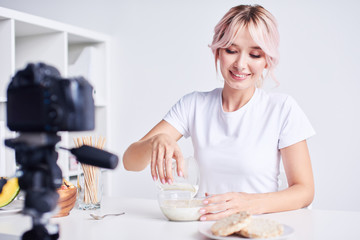 Young woman cooking breakfast for food blog
