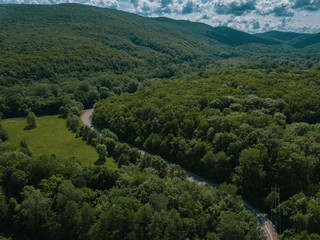 Obraz premium Aerial view of a rural highway between mountains