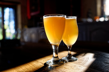 glass of beer on a wooden table with sunset 