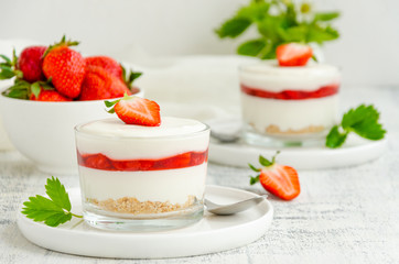No baked strawberry cheesecake in a glass on a wooden background. Summer cold dessert. Horizontal, copy space.