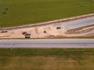 Road Construction Site near the highway with machinery, bulldozer, excavation from above. 4K video, top down view.