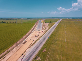 Road Construction Site near the highway with machinery, bulldozer, excavation from above. 4K video, top down view.