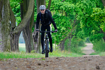 Fototapeta na wymiar A man on a bicycle riding on a forest path.