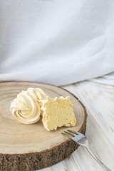 Sweets zefir or zefyr, yellow marshmallows on a plate on a light background