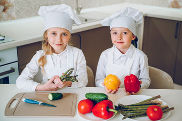 little cooks cut vegetables for salad