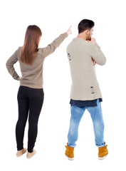 Back view of couple in sweater with mobile phone.