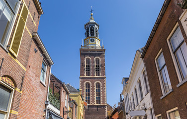 Fototapeta na wymiar Street with old houses leading to the historic belfry of Kampen, Netherlands