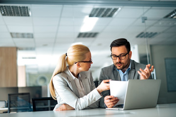 Business people discussing work. Serious female manager talking to a male employee, asking for explanation, portrait.