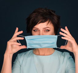 woman puts on a protective mask