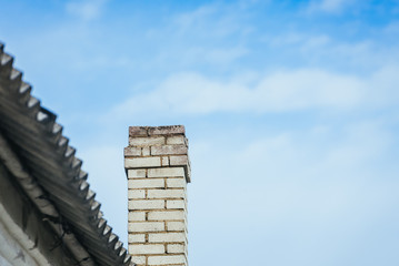 Chimney on the roof of the house against the blue sky