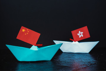 paper ship with national flag of china and hong kong, concept of conflict, shipment or free trade...