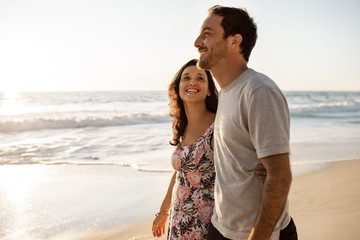 Loving young couple walking together along a sandy beach